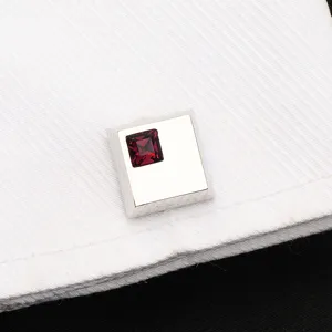 Gros plan de elegants boutons de manchette carres en cristal sur chemise blanche detail.