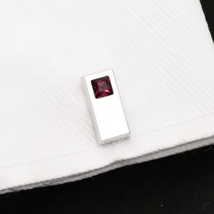 Gros plan macro détaillé de bouton de manchette rectangulaire en métal avec cristal rouge.