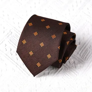 Brown men's tie detail showing neat roll texture with yellow geometric dot pattern.