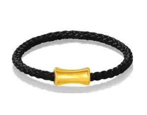 Black braided leather bracelet featuring a central gold metal tube, stylish minimalist.