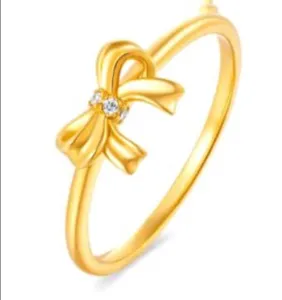Gold tone bowknot ring detail featuring sparkling crystal accents and sleek polished band.