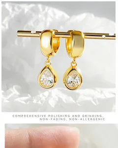 Detail shot of exquisite teardrop zircon hoop earrings with polished gold finish and luxury look.