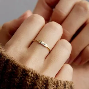 Gros plan détaillé de bague dorée minimaliste avec plaque gravée, bijou élégant.
