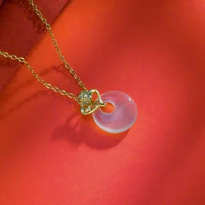 Elegante goudkleurige ketting met doorschijnende chalcedoon vredesgesp en bloemenhanger.