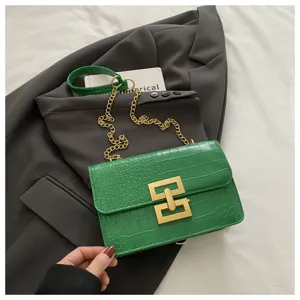Groene schoudertas met krokodillenpatroon, gouden ketting en chique slot voor dames.