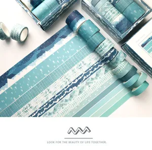 Vista detallada de rollos de cinta washi azul y tiras decorativas con hermosos patrones de montañas.