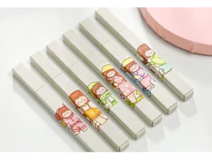 Primo piano dettagliato di simpatiche penne di cancelleria con illustrazioni di personaggi kawaii.