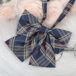 Detailed close-up of a Japanese JK style navy blue plaid bow tie with ribbons, apparel accessory.