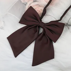 Close-up detail of dark brown JK uniform bow tie ribbon, featuring elegant fabric texture.