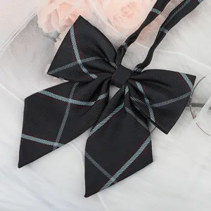 Detailed view of a black plaid JK uniform bow tie, featuring classic stripes and long ribbons.