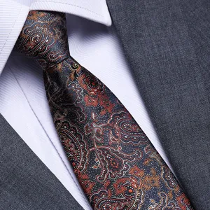 Detailed view of a men's business paisley tie paired with a white shirt and grey suit.
