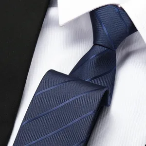 Men's dark blue striped tie with formal white business dress shirt and suit for wedding.