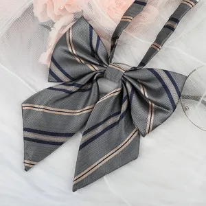 Detailed close-up of a stylish JK uniform bow tie with classic striped herringbone pattern.
