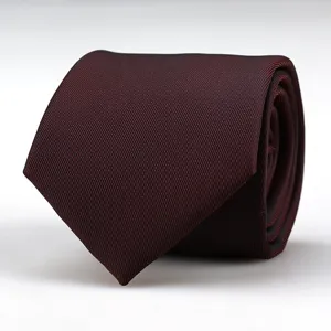 Detailed view of a dark red textured men's necktie, rolled up neatly, elegant formal wear.