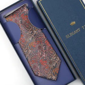 Detailed view of a navy blue paisley necktie with orange patterns in a luxury gift box.