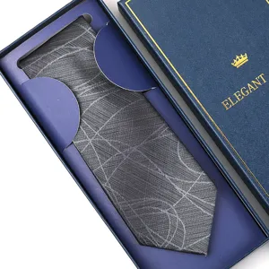 Detailed view of a classy grey patterned necktie neatly packed inside a dark blue premium gift box.