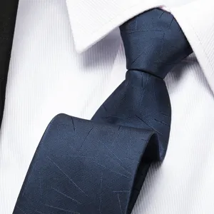 Close-up detail of a classic navy blue men's business necktie with abstract lines pattern.