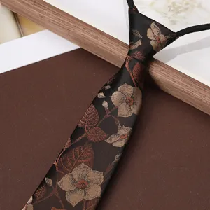 Close-up detail of mens vintage floral zipper tie, black fabric with fine leaf pattern.