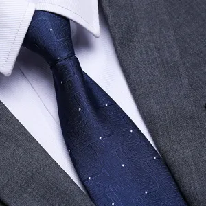 Close-up detail of the elegant navy blue patterned tie texture, professional business suit style.
