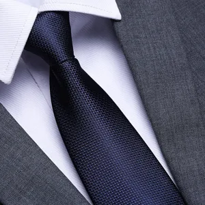 Men dark blue textured necktie detail shot, premium formal business suit tie accessory.