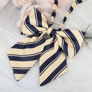Close-up of classic navy blue and beige striped JK uniform bow tie with ribbon detail.