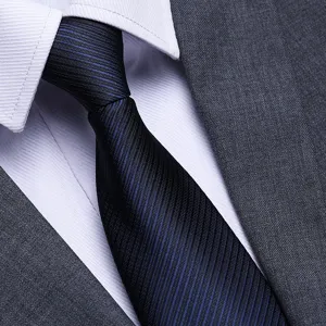 Close-up detail shot of a classic dark blue textured mens business tie with white shirt.
