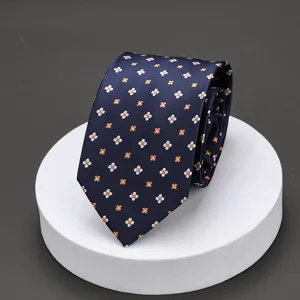 Detailed view of mens dark blue necktie with orange and white floral pattern for business suit.