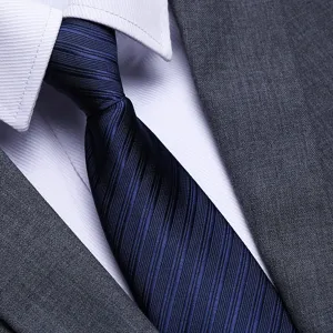 Close up view of the dark blue textured necktie fabric detail, paired with formal wear.