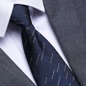 Men's blue geometric pattern tie detail view, elegant business suit necktie close-up texture.