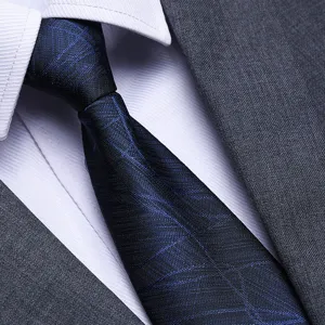 Close-up detail of a mens classic blue geometric patterned business tie with suit jacket and shirt.