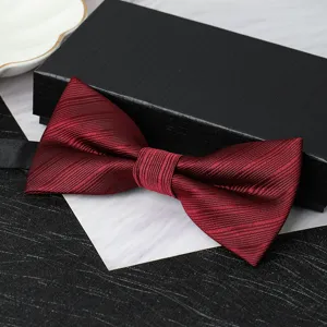 Detail view of a burgundy red men's formal bow tie with black gift box packaging and texture.