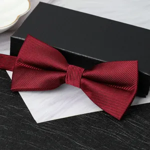Detailed view of a burgundy ribbed bow tie with gift box for formal wedding suits.