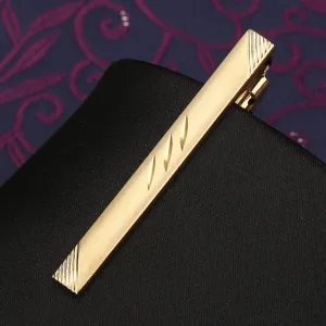 Gold metal tie clip close up, stylish men suit accessory, elegant striped pattern design.