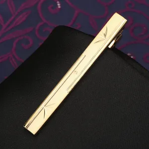 Gold metal tie clip featuring elegant engraved starburst details for men business suits.