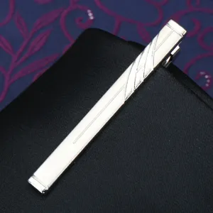 Silver metal tie clip detail view, elegant men's business suit accessory with stripe pattern.