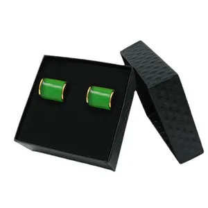 Eleganti gemelli da polso cilindrici verdi con bordo dorato in elegante confezione regalo.