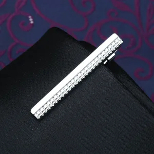 Detail view of a sleek silver metal tie clip featuring elegant textured grid pattern design.