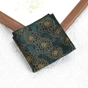 Close-up detail van een donkergroen heren pocquet met elegant gouden bloemenpatroon.