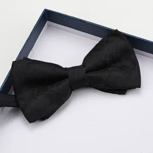 Primo piano dettagliato di un classico papillon nero testurato presentato in una scatola.