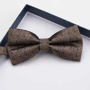 Dettaglio in primo piano di un elegante papillon marrone a pois in scatola regalo blu.