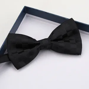 Primo piano del papillon nero a quadri nella scatola, dettaglio formale, tessuto elegante.