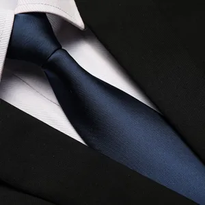 Close-up detail of a classic blue business necktie paired with white shirt and black suit.