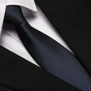 Close-up detail of a dark blue striped business necktie paired with a white shirt.