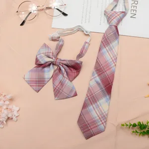 Detailed view of pink and blue plaid JK uniform tie and bow accessory set flat lay.