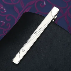 Silver metal tie clip detail showing diagonal textured pattern and embedded clear rhinestone.