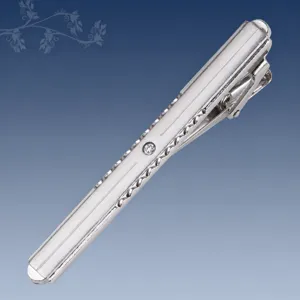 Primer plano detallado del clip para corbata de metal plateado con cristal brillante.