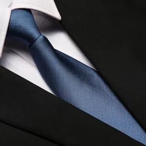 Detailed view of a stylish blue textured business necktie paired with white shirt and suit.