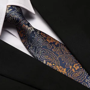 Detail view of a classic blue paisley necktie paired with a crisp white shirt.