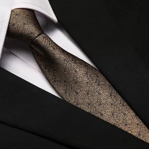 Close-up detail of a classic brown textured tie with subtle blue dots, elegant and stylish.