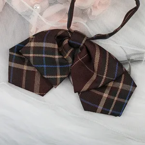 Detaillierte Nahaufnahme der braunen karierten JK Uniform Fliege mit klassischem Karomuster.